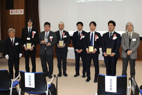 第18回岩木賞受賞者と関係者 左から、藤井氏、コニカミノルタジャパン・西本氏、コニカミノルタジャパン・若園敏美氏、日本食品化工・高口氏、日本食品化工・堀之内 歩氏、新東科学・北田暢也氏、ハイロックス・上代永氏、大森会長　mst 表面改質